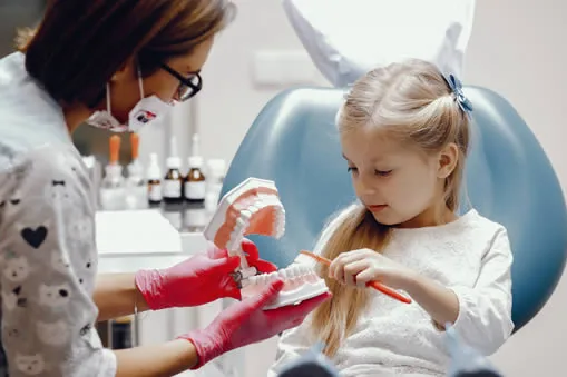 Young child at the dentist learning to brush teeth
